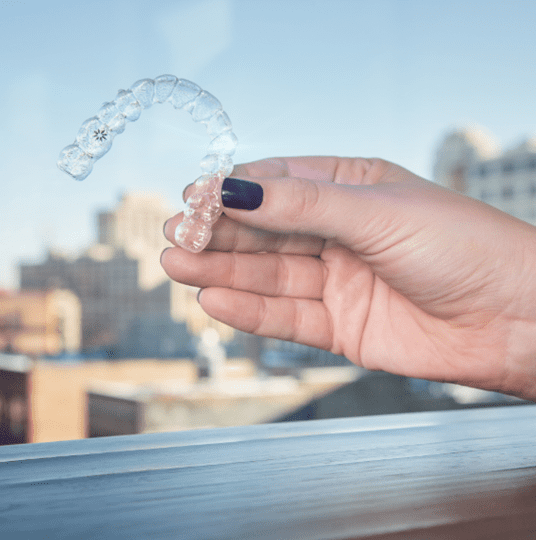 mano sujetando invisalign